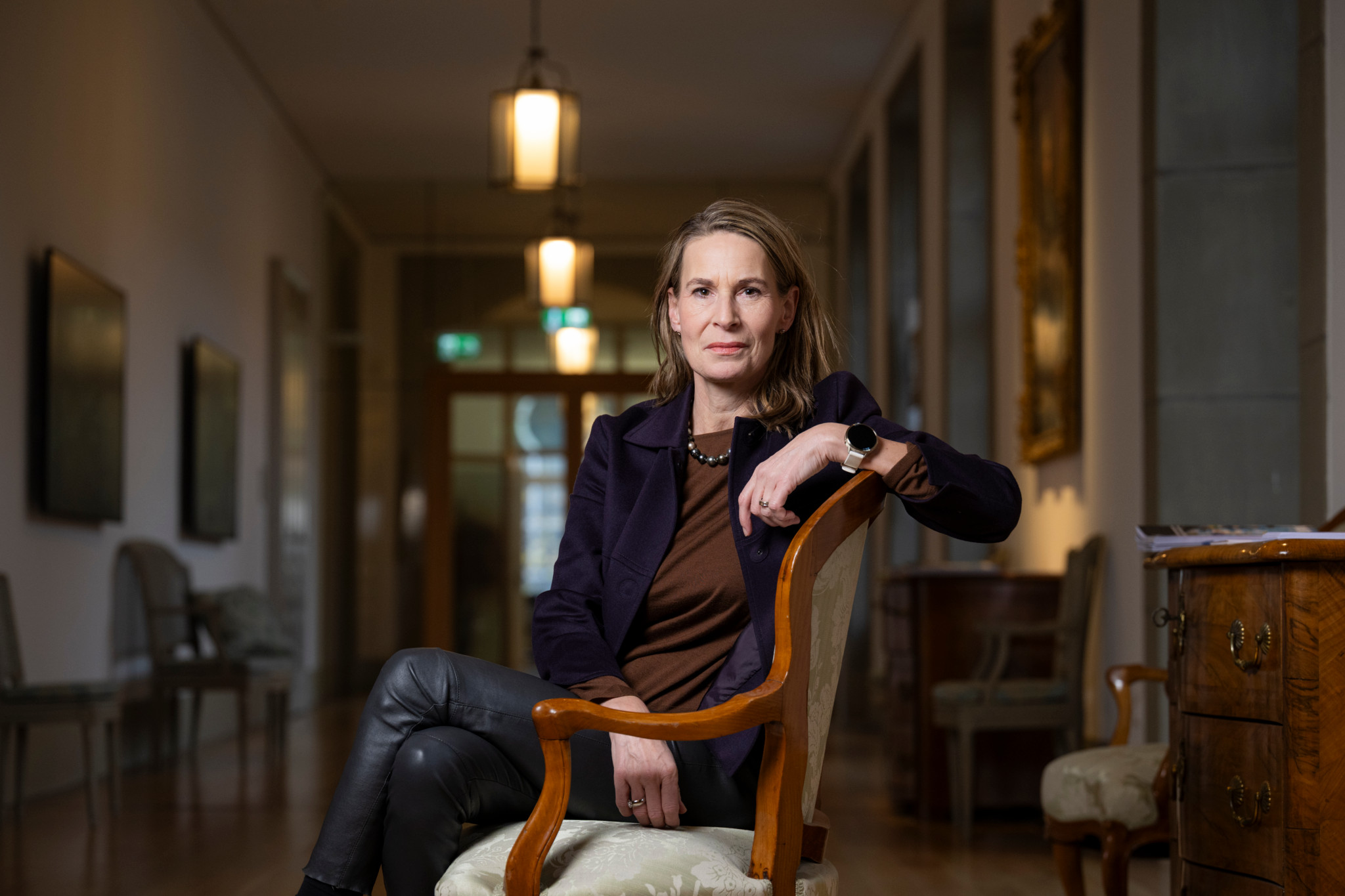 Katja Gentinetta sitzt in einem Sessel in einem elegant eingerichteten Raum in Bern.